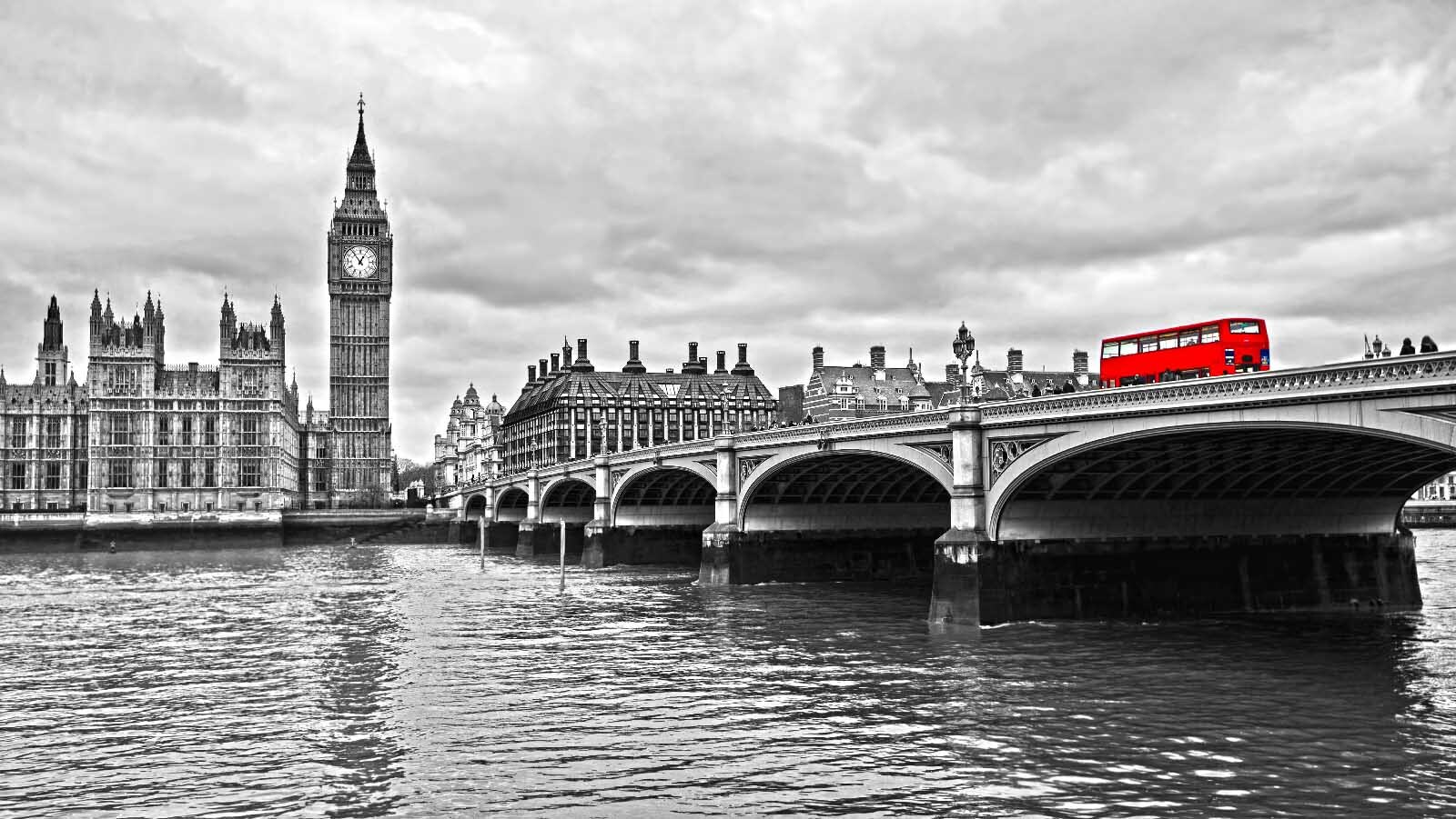 Bridge over water with a clock tower and a red bus