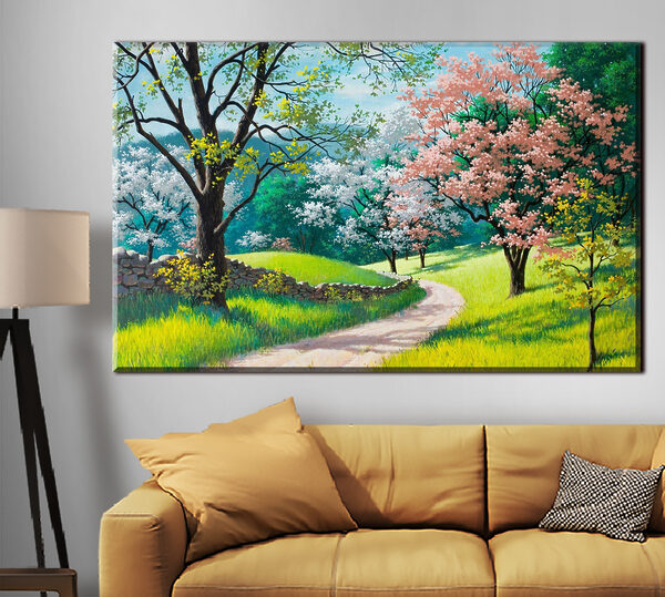 A dirt road through a grassy field with trees and a stone wall A dirt road through a grassy field with trees and a stone wall
