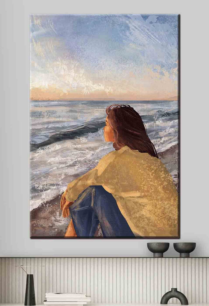 A woman sitting on a beach looking out to the ocean
