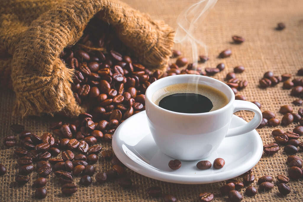 A cup of coffee and a bag of coffee beans A cup of coffee and a bag of coffee beans