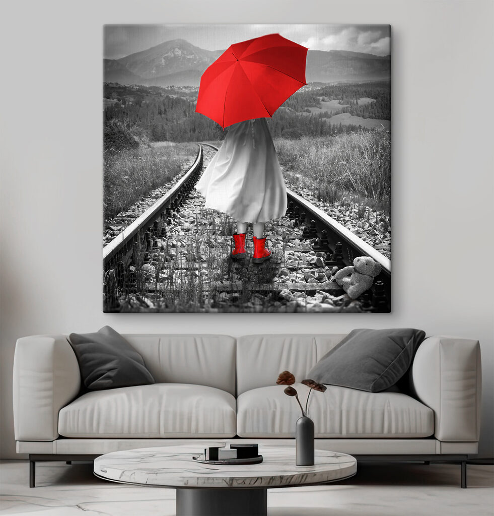 A person with a red umbrella on a train track