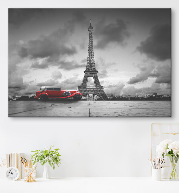 A red car parked in front of a large tower A red car parked in front of a large tower