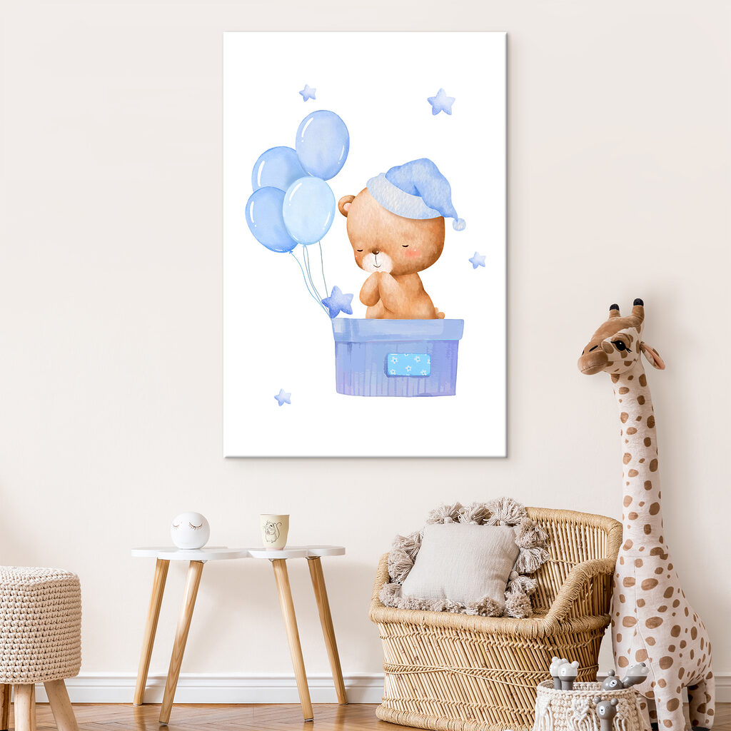 A teddy bear in a box with balloons