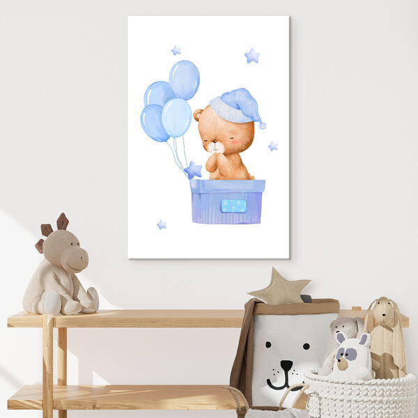 A teddy bear in a box with balloons