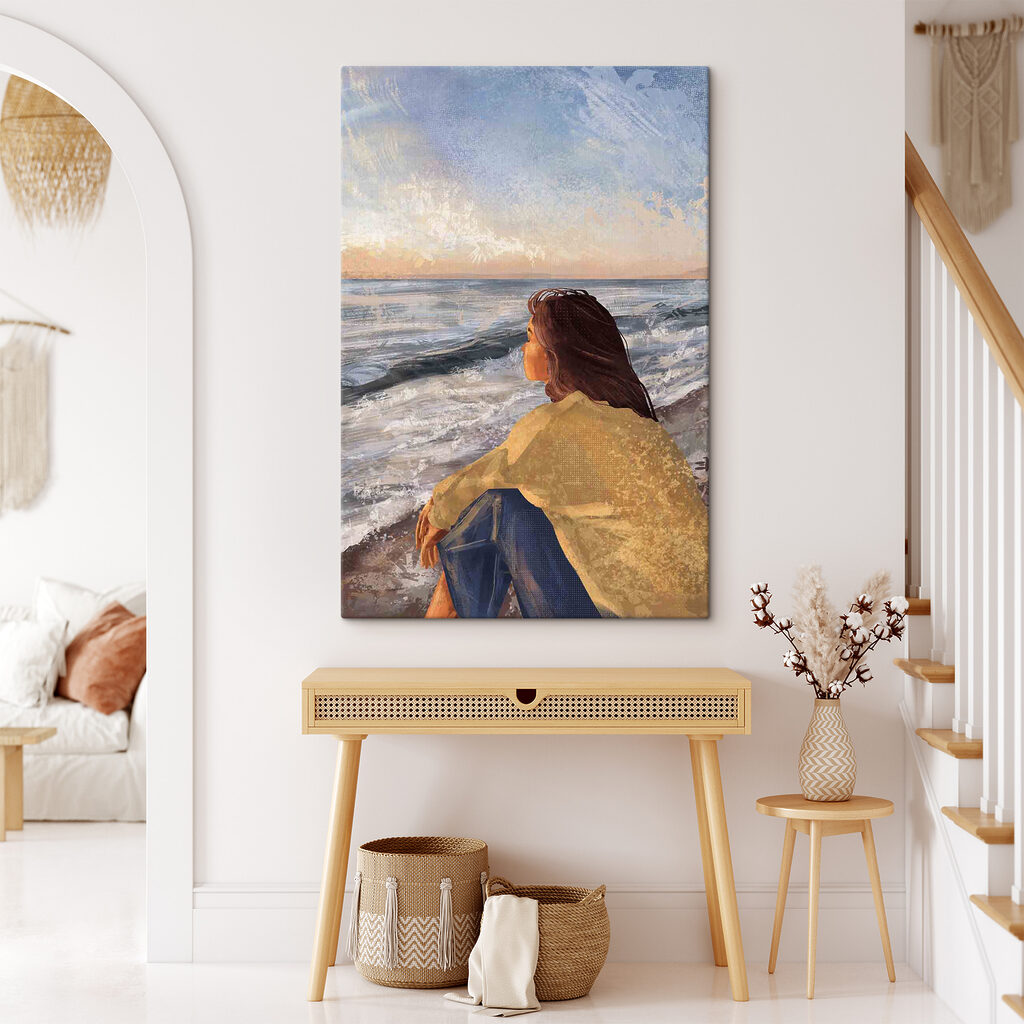 A woman sitting on a beach looking out to the ocean