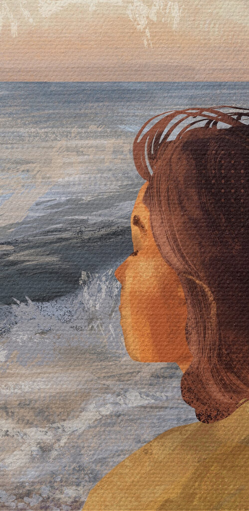 A woman sitting on a beach looking out to the ocean