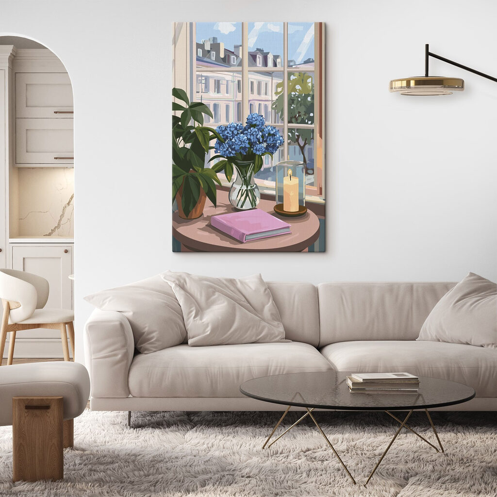 Vase of flowers and a candle in front of a window